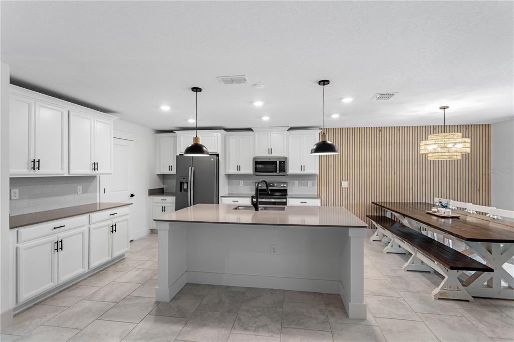 5693 Alenlon Way Mount Dora, FL 32757 - Photo 8 of 40 a kitchen with a sink stove and cabinets
