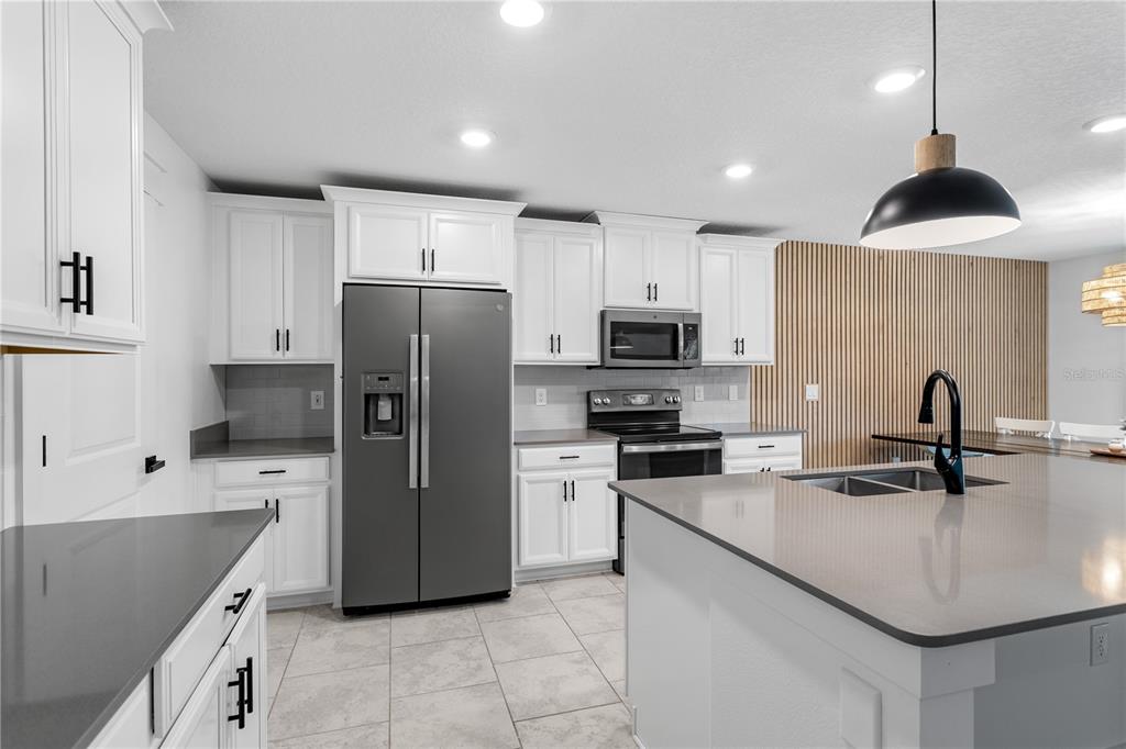 5693 Alenlon Way Mount Dora, FL 32757 - Photo 10 of 40 a kitchen with a sink stainless steel appliances and counter space