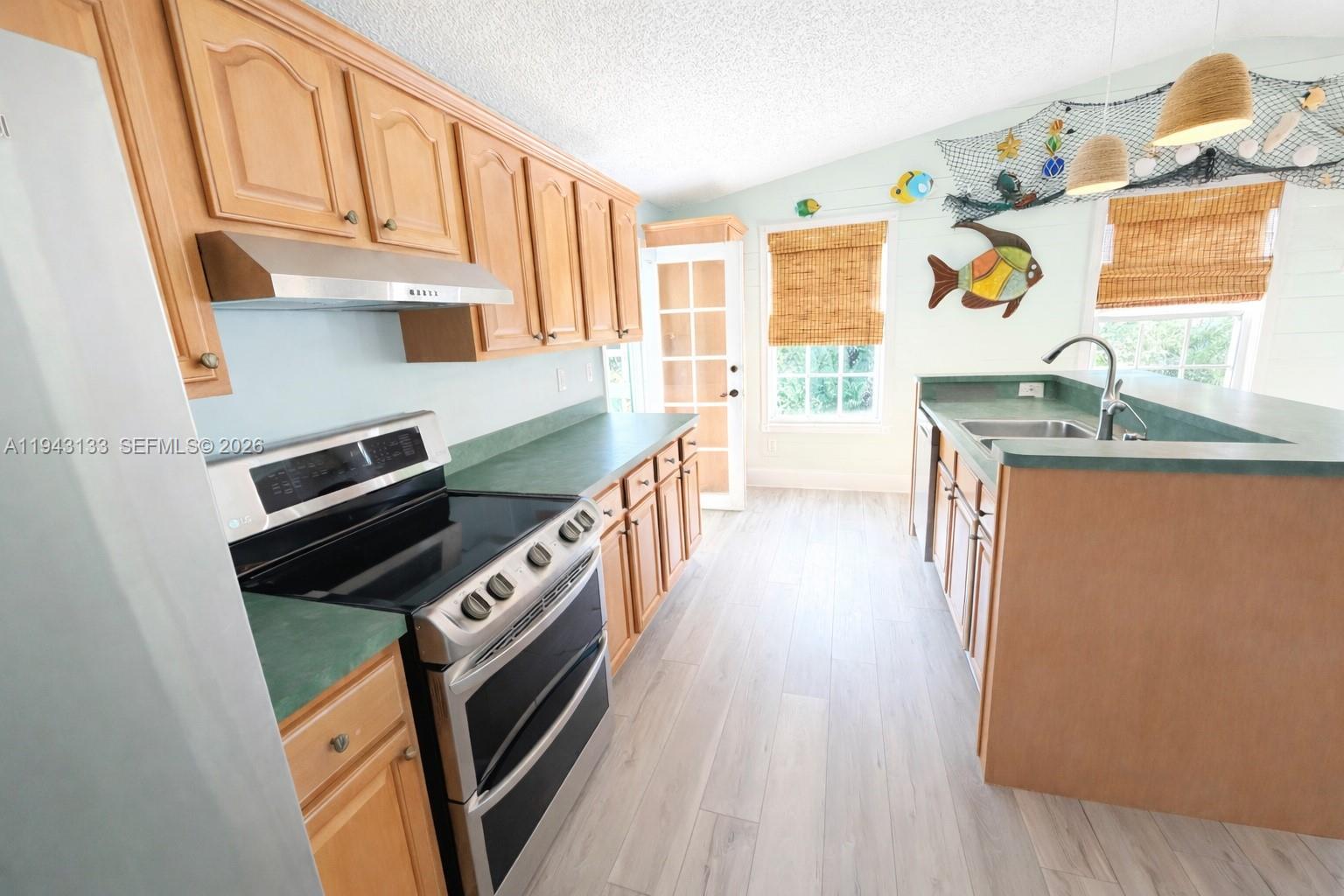 61 Central Avenue Key Largo, FL 33037 - Photo 4 of 21 a kitchen with stainless steel appliances a stove a sink and a microwave
