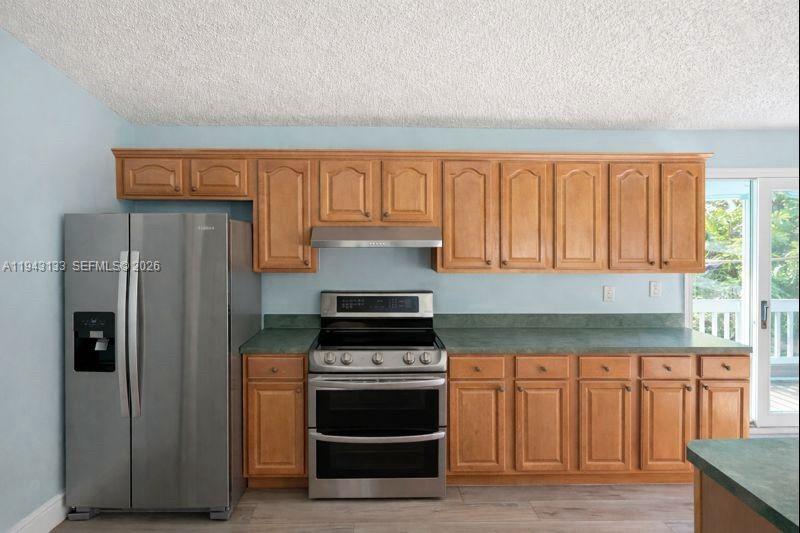 61 Central Avenue Key Largo, FL 33037 - Photo 5 of 21 a kitchen with granite countertop a stove and a refrigerator