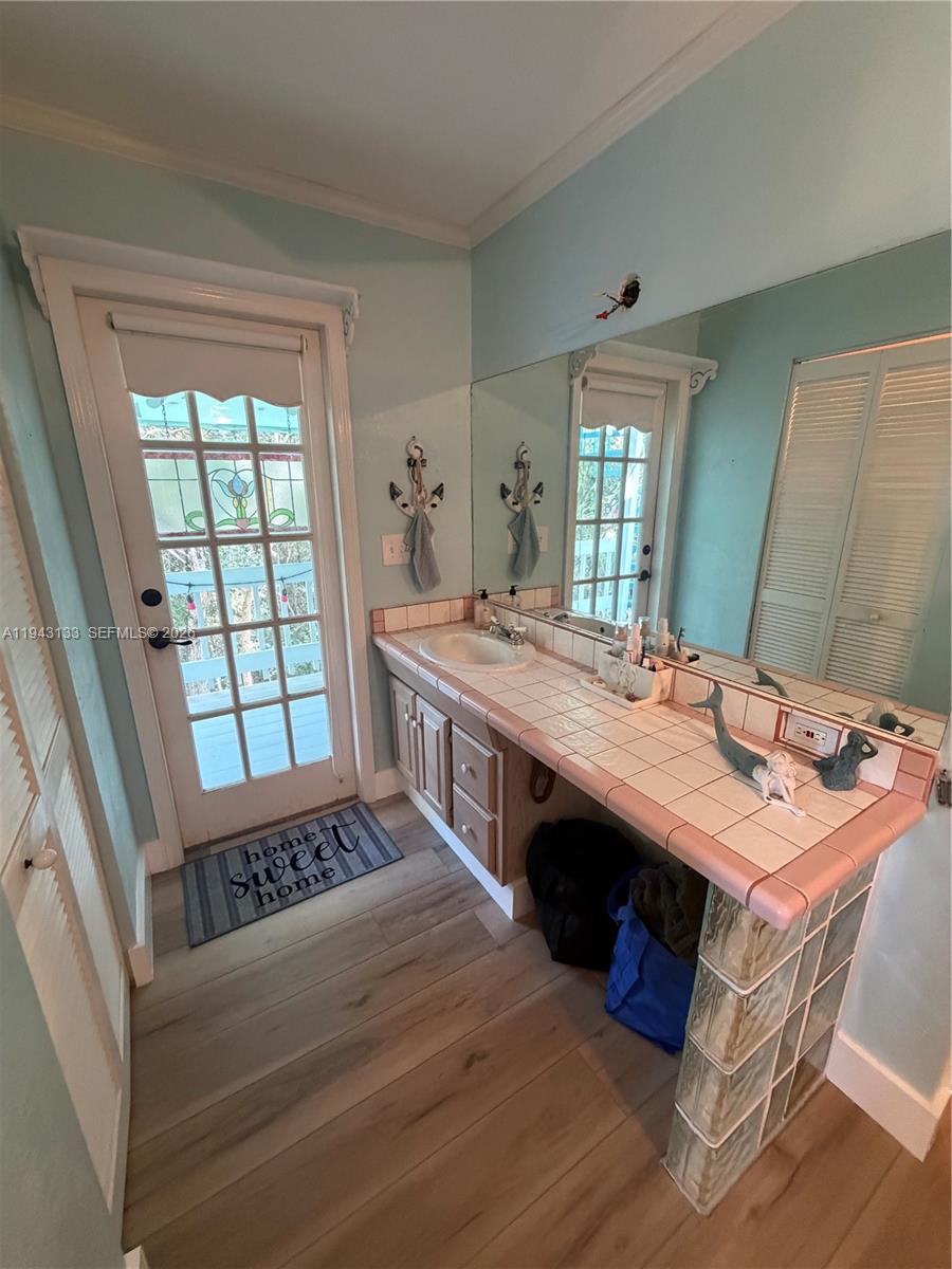 61 Central Avenue Key Largo, FL 33037 - Photo 8 of 21 a dining room with a table chairs and a wooden floor