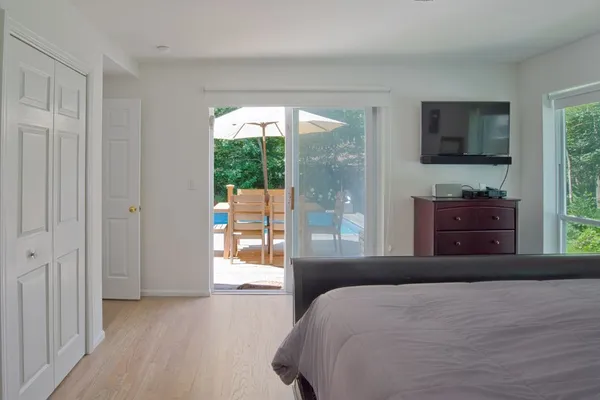 a bedroom with a large bed and a flat tv screen