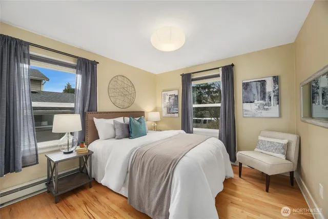 a bedroom with a bed two lamp on desk and a window
