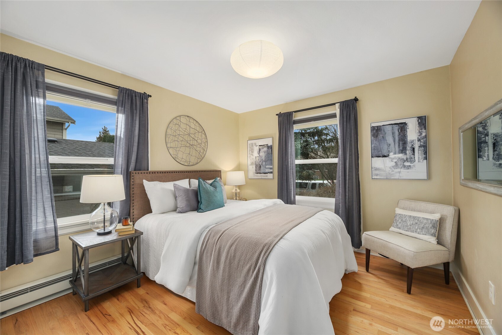 3239 45th Avenue Southwest Seattle, WA 98116 - Photo 11 of 39 a bedroom with a bed two lamp on desk and a window