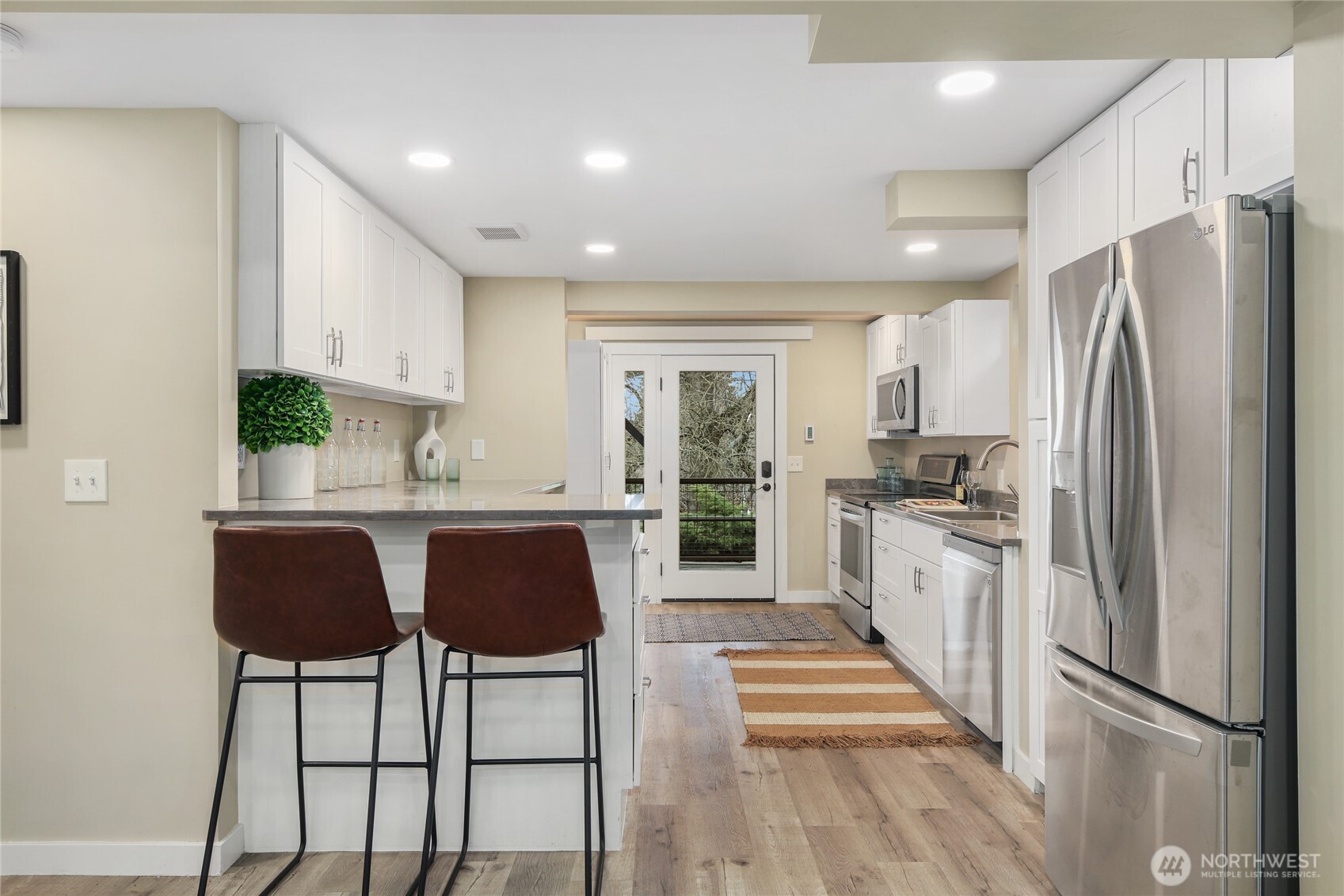 3239 45th Avenue Southwest Seattle, WA 98116 - Photo 27 of 39 a kitchen with stainless steel appliances granite countertop a refrigerator and a stove top oven with wooden floor
