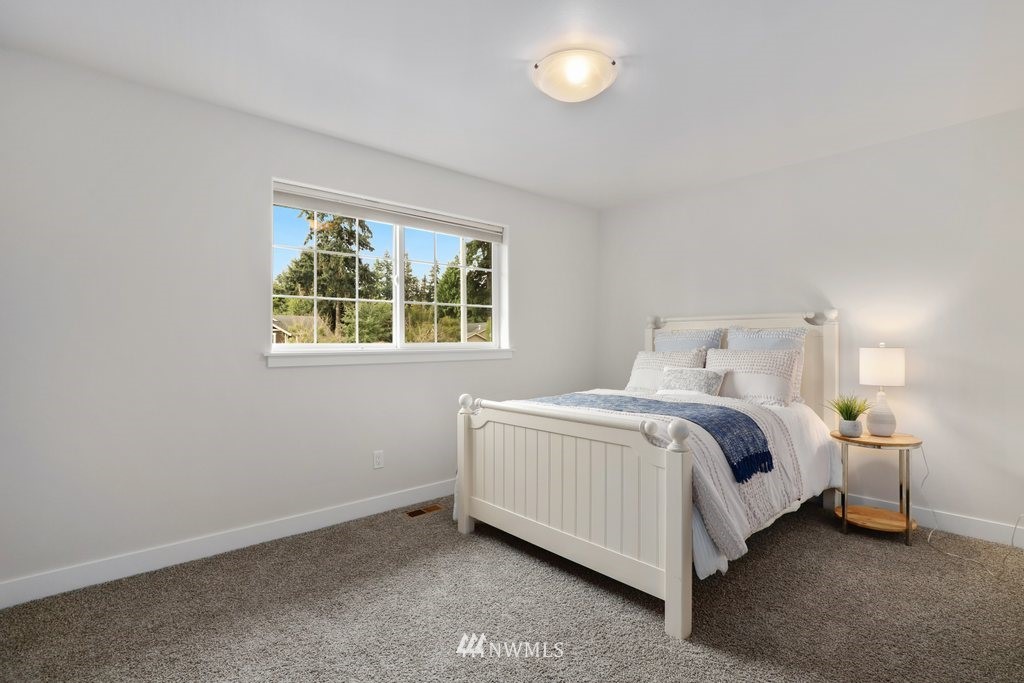 113 233rd Place Southeast Bothell, WA 98021 - Photo 23 of 39 a bedroom with a bed lamp and a window