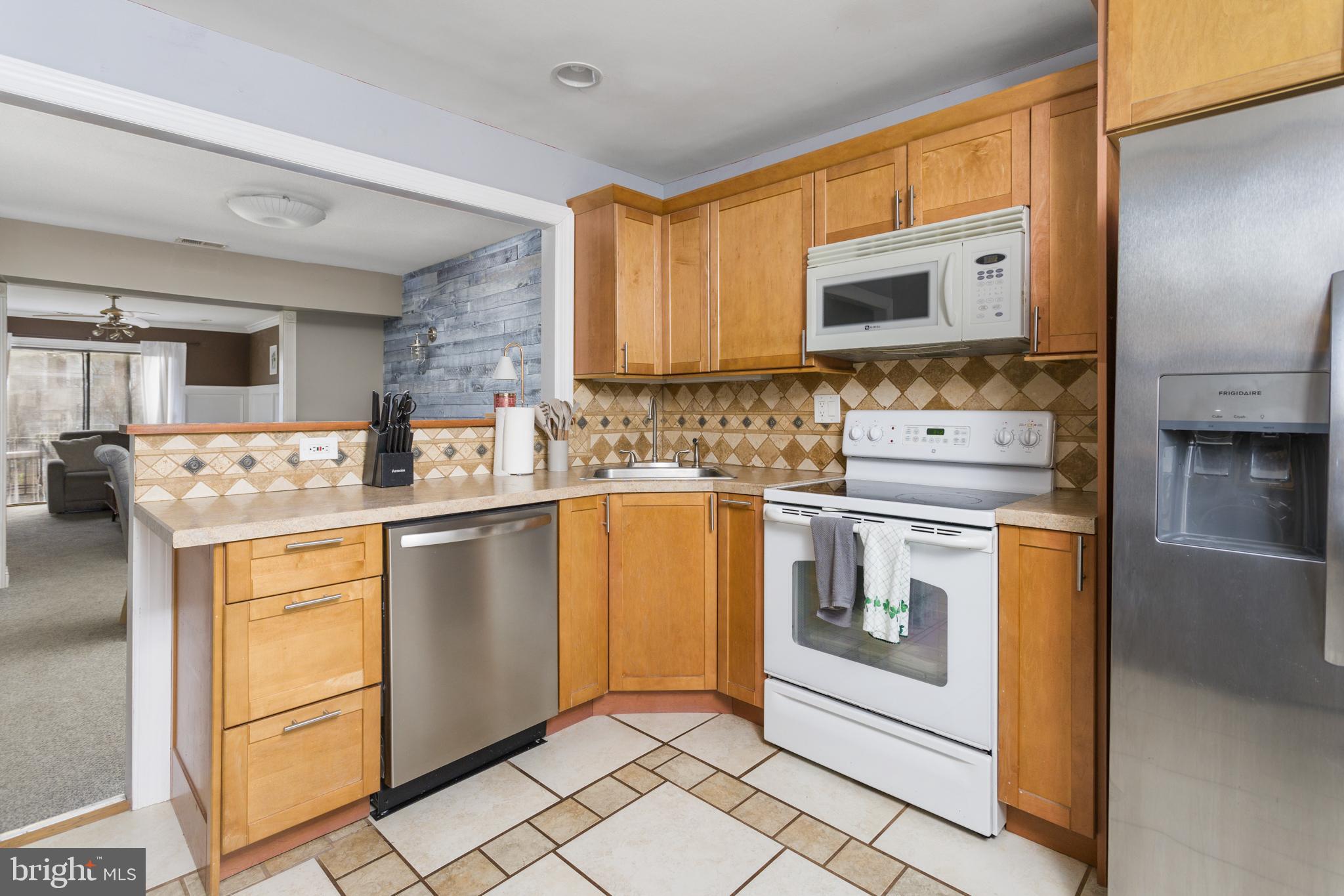 912 Silver Court Hamilton, NJ 08690 - Photo 14 of 22 a kitchen with stainless steel appliances granite countertop a stove a sink and a microwave