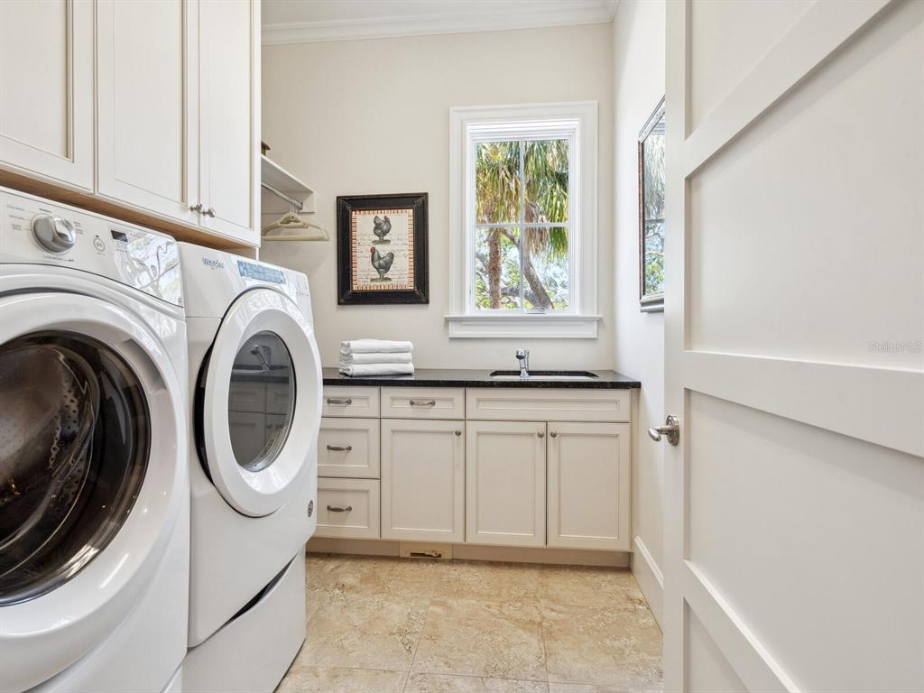 7333 Point Of Rocks Road Sarasota, FL 34242 - Photo 28 of 81 a bathroom with a sink a washer and dryer next to a window