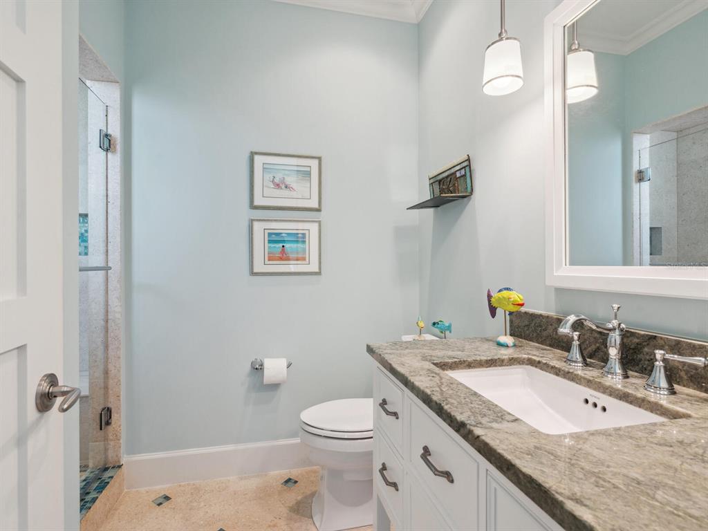 7333 Point Of Rocks Road Sarasota, FL 34242 - Photo 35 of 81 a bathroom with a granite countertop toilet a sink and a mirror