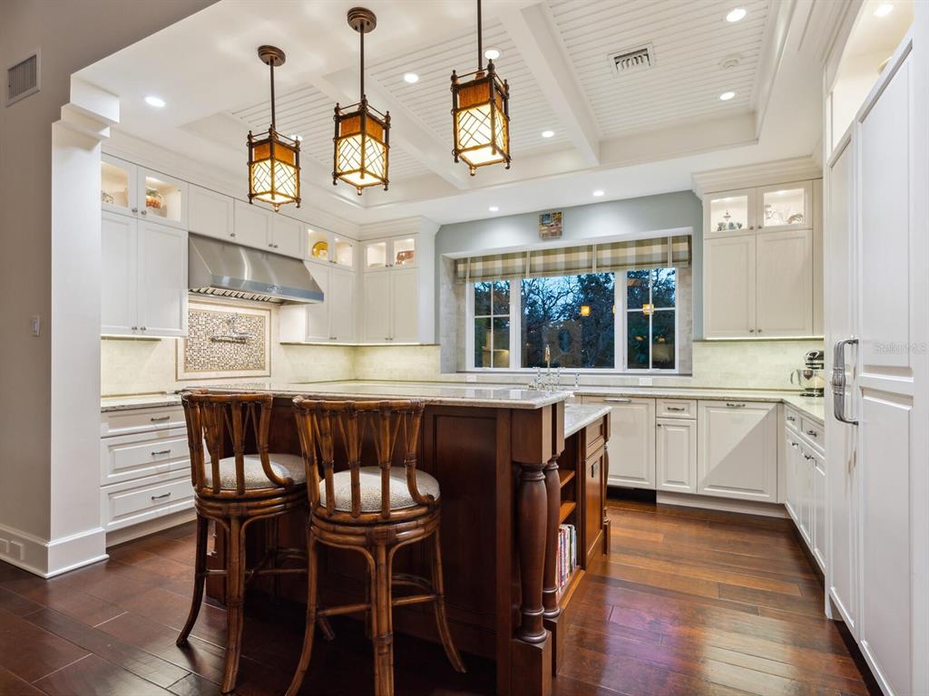 7333 Point Of Rocks Road Sarasota, FL 34242 - Photo 60 of 81 a kitchen with stainless steel appliances granite countertop a kitchen island a stove a table and chairs in it