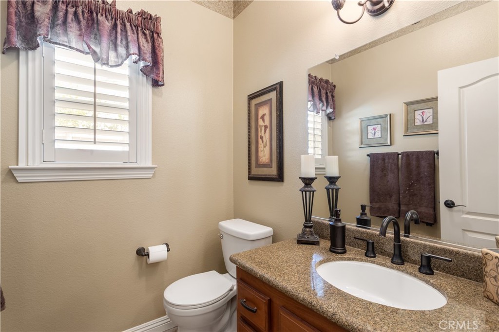 33351 Nicholas Common Temecula, CA 92592 - Photo 19 of 42 a bathroom with a granite countertop toilet sink and mirror
