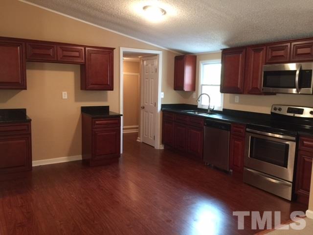 1390 Langdon Road Angier, NC 27501 - Photo 5 of 24 a kitchen with stainless steel appliances granite countertop a stove a refrigerator and a microwave