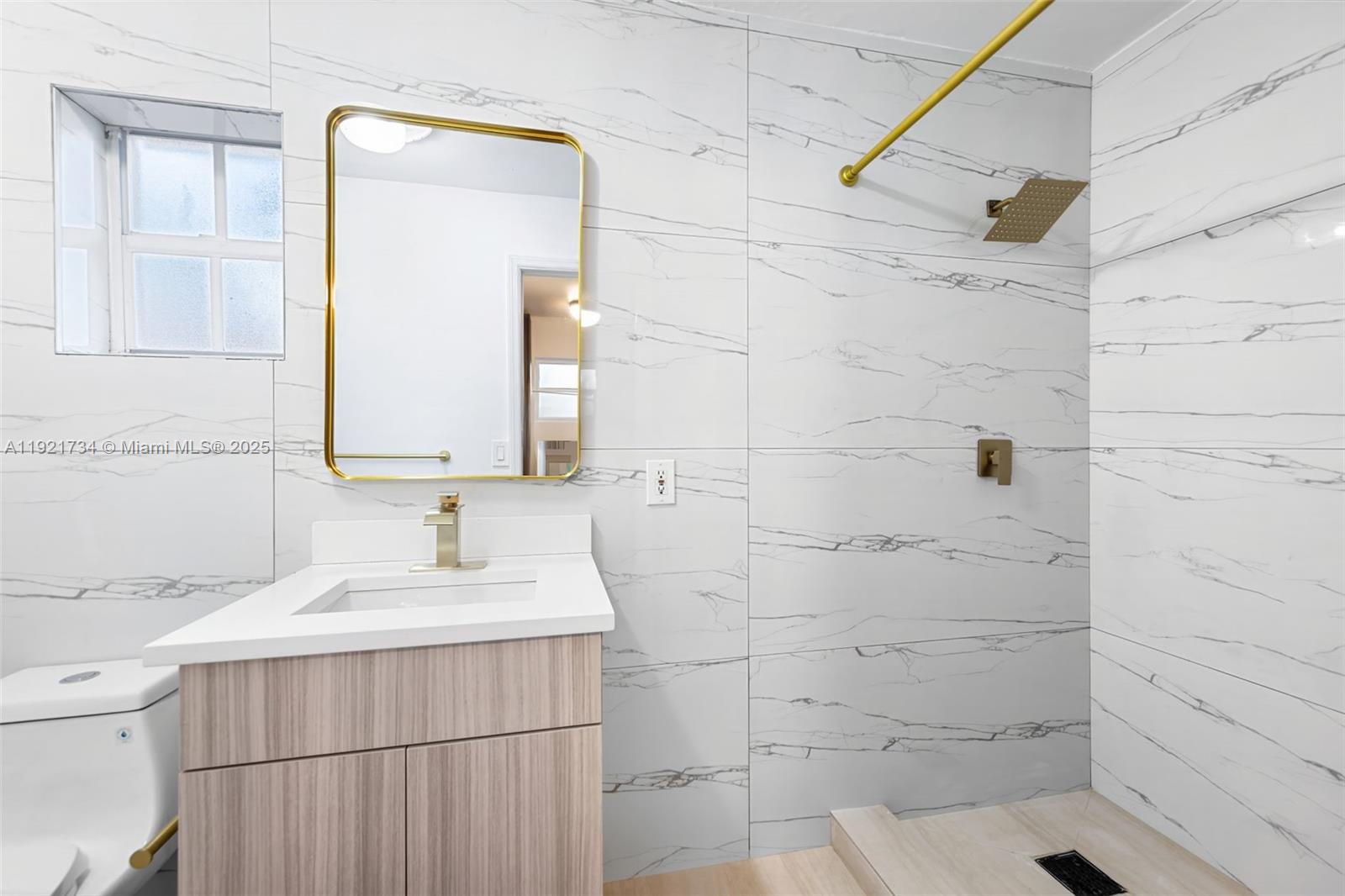 23 Southwest 8th Street Hallandale Beach, FL 33009 - Photo 11 of 18 a bathroom with a sink and a mirror