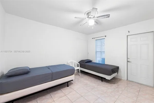 a living room with a bed furniture and a ceiling fan