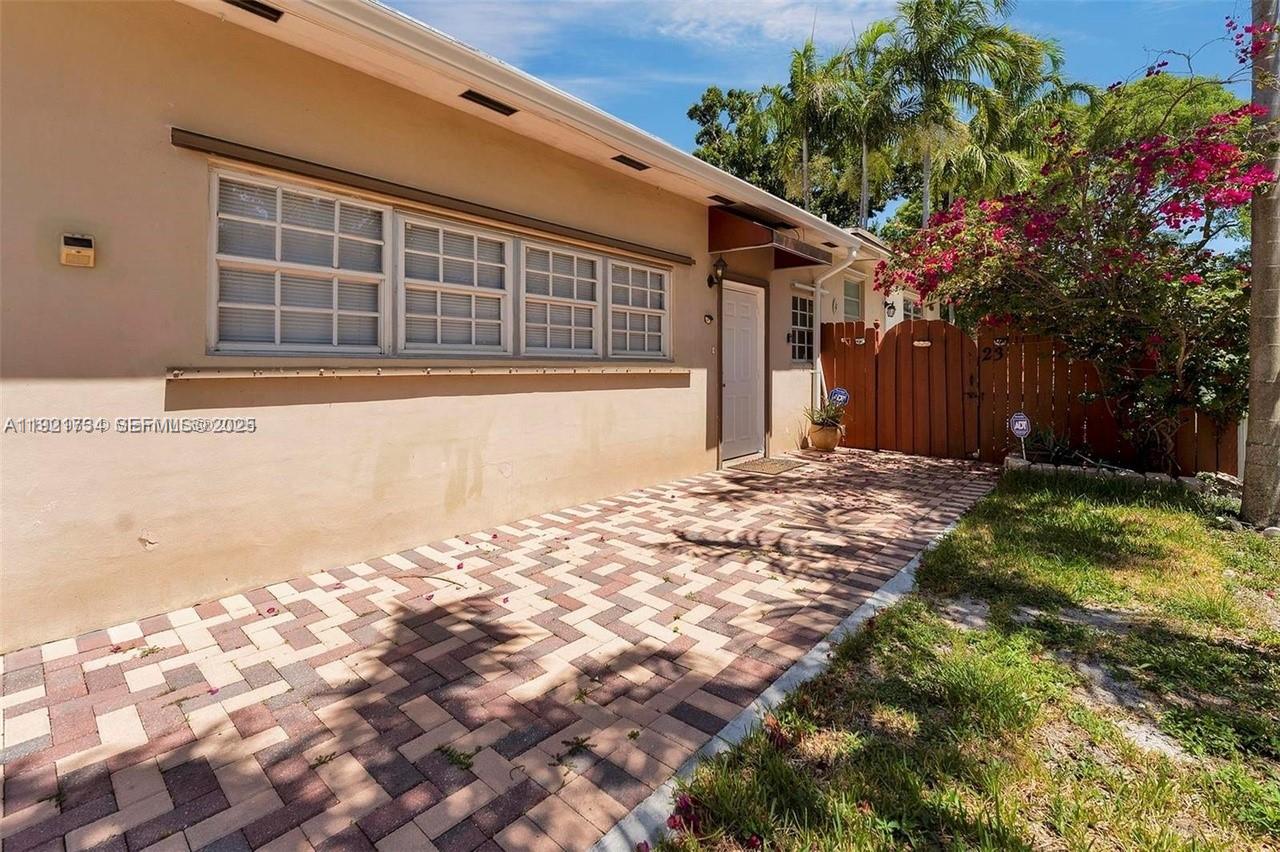 23 Southwest 8th Street Hallandale Beach, FL 33009 - Photo 5 of 18 a front view of a house with a yard