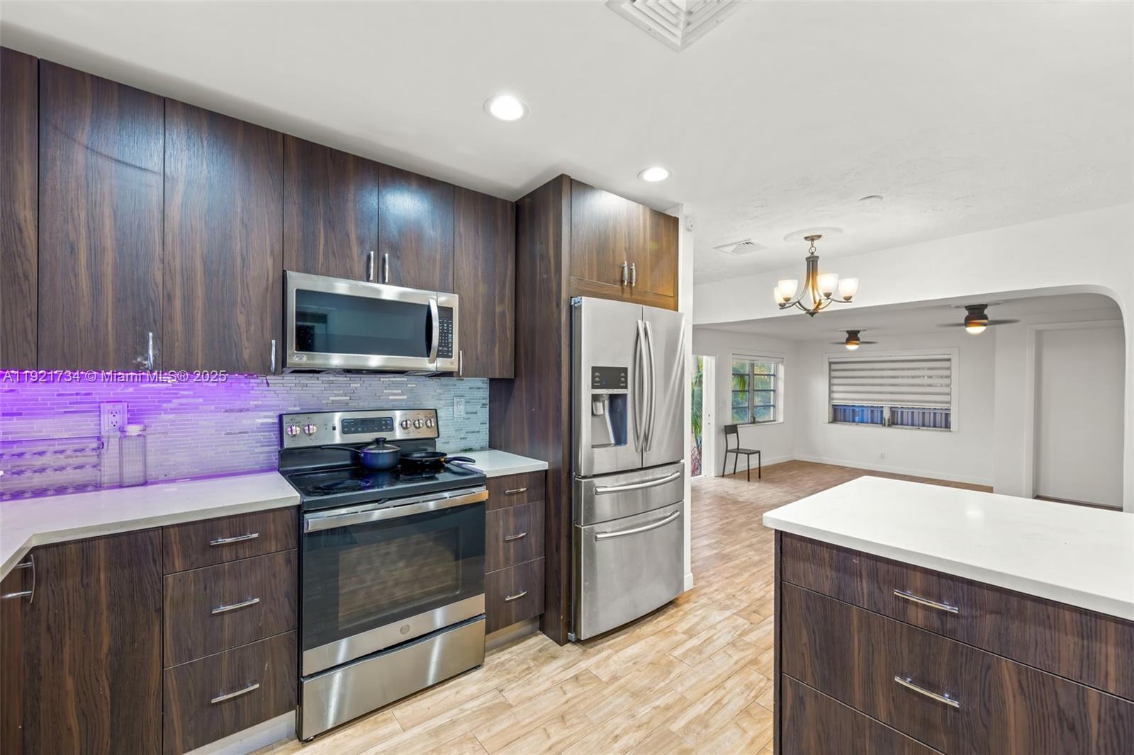 23 Southwest 8th Street Hallandale Beach, FL 33009 - Photo 9 of 18 a kitchen with granite countertop stainless steel appliances and cabinets