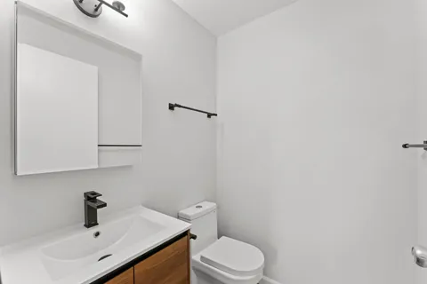 a bathroom with a sink a toilet and vanity