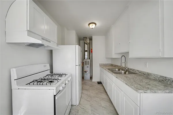 a kitchen with a stove a refrigerator and a sink