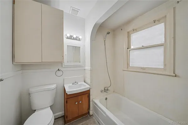 a bathroom with a granite countertop toilet a sink and bathtub
