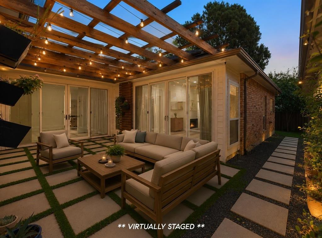 14140 Regency Place Dallas, TX 75254 - Photo 33 of 38 Expansive outdoor patio featuring a wooden pergola with string lights, large format patio pavers, and a gravel and stepping stone pathway
