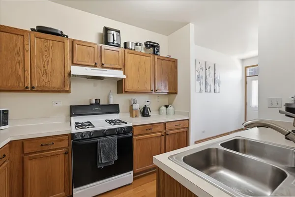 a kitchen with granite countertop a sink a stove and cabinets