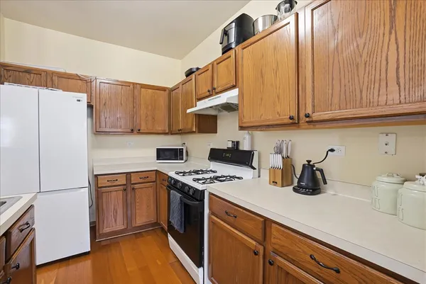 a kitchen with stainless steel appliances granite countertop a refrigerator sink and stove
