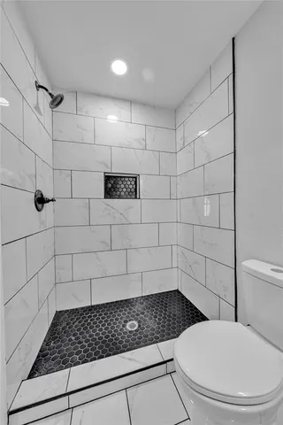 a bathroom with a toilet and a shower