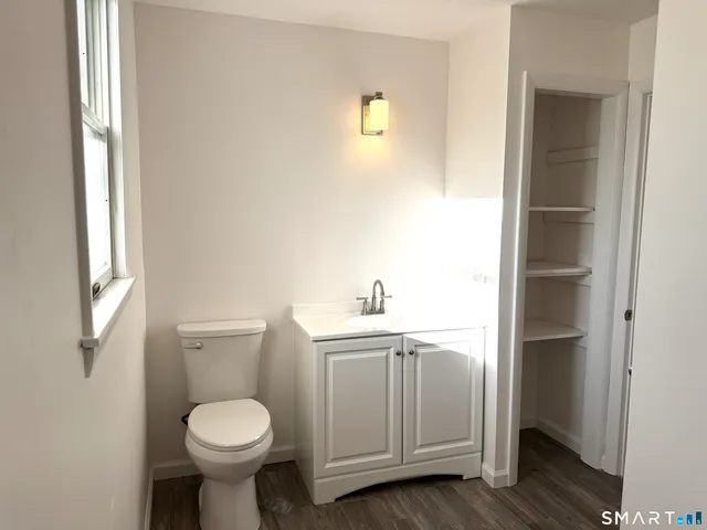 a bathroom with a sink a toilet and with window