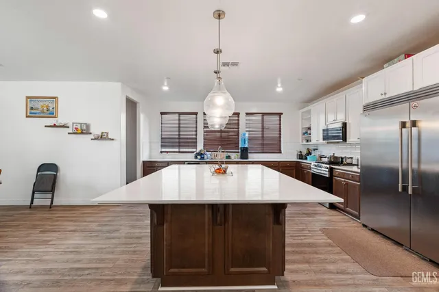 a large kitchen with kitchen island a counter space a sink appliances and cabinets