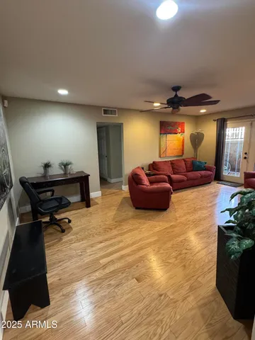 a living room with furniture and a wooden floor