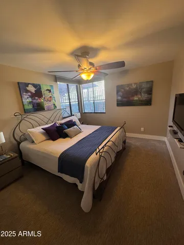 a bedroom with a bed and a painting on the wall