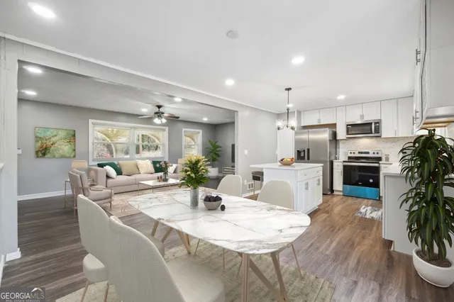 a living room with stainless steel appliances kitchen island granite countertop furniture and wooden floor