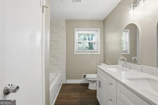 a bathroom with a double vanity sink a toilet and a window
