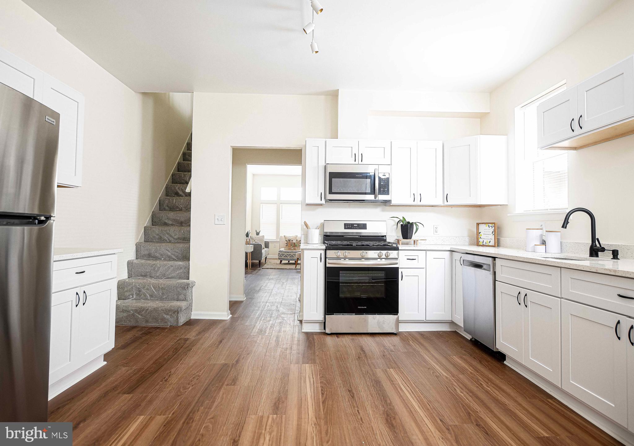 535 North Decker Avenue Baltimore, MD 21205 - Photo 11 of 24 a kitchen with stainless steel appliances a white cabinets and wooden floor