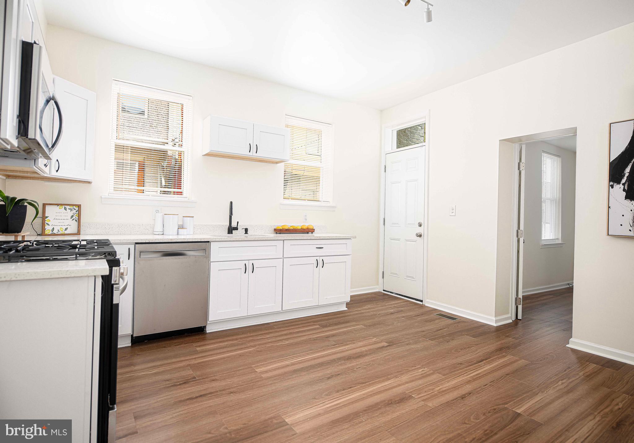535 North Decker Avenue Baltimore, MD 21205 - Photo 13 of 24 a kitchen with a sink cabinets stainless steel appliances and wooden floor