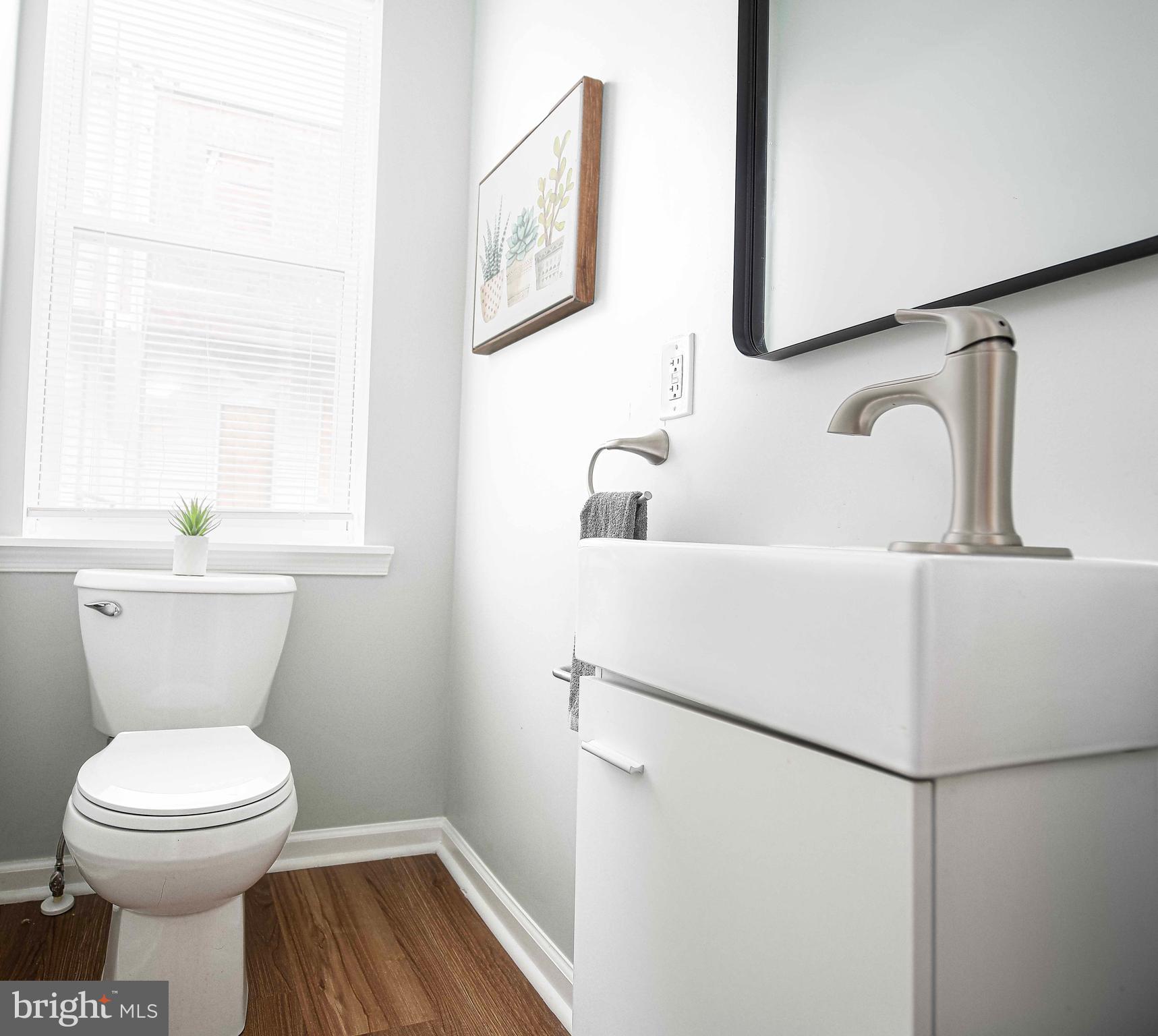 535 North Decker Avenue Baltimore, MD 21205 - Photo 10 of 24 a bathroom with a toilet sink and mirror