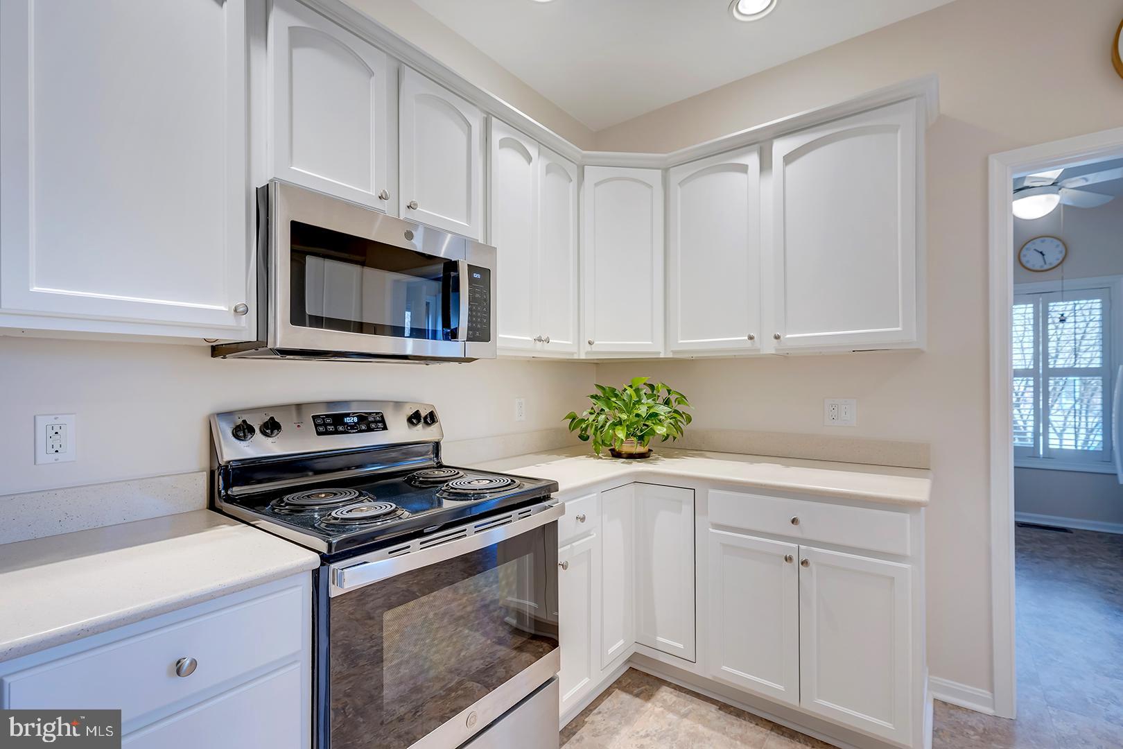 33006 Deer Trail Millville, DE 19967 - Photo 12 of 54 a kitchen with white cabinets and appliances