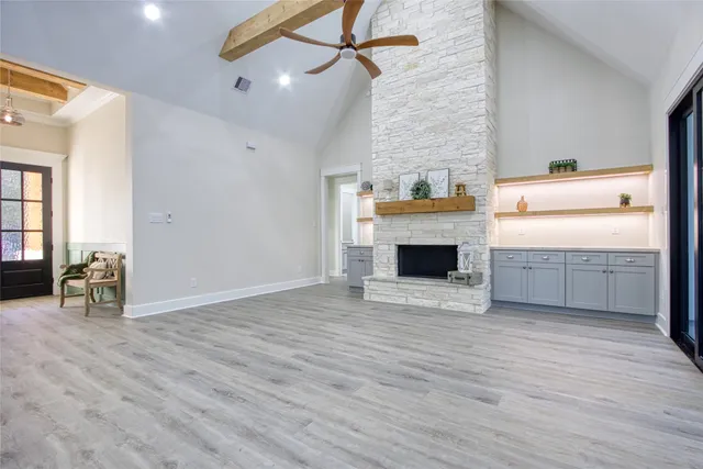a view of empty room with wooden floor and fireplace