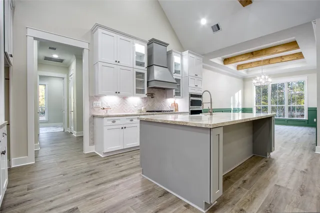 a large kitchen with stainless steel appliances granite countertop a lot of counter space and wooden floors