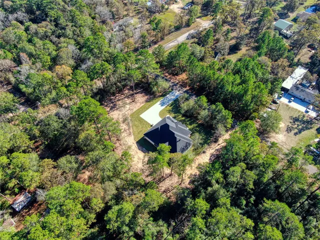 an aerial view of a house with a yard and large trees