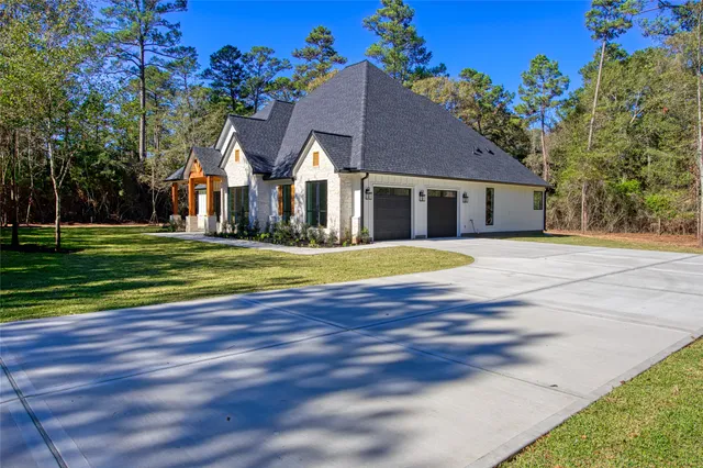a view of a house with a big yard and large trees