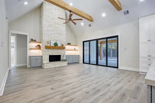 a view of empty room with wooden floor and fireplace