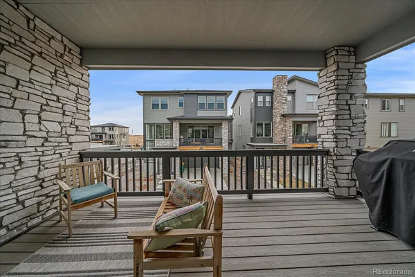 a view of a balcony with two chairs and wooden floor