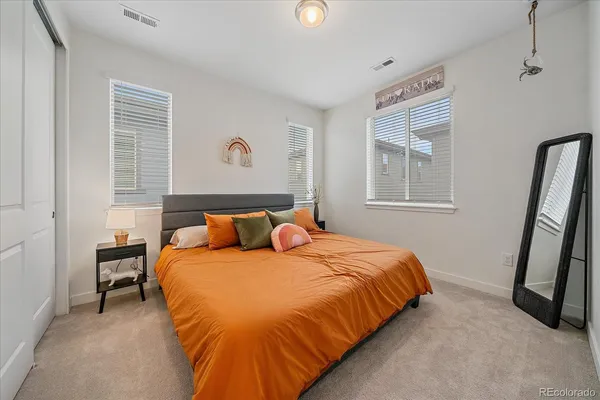 a bedroom with a bed and a flat tv screen on the wall