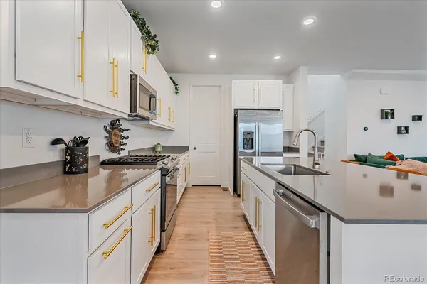a kitchen with kitchen island a sink appliances cabinets and a counter top space