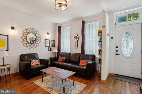 a living room with furniture a wooden floor and a large window