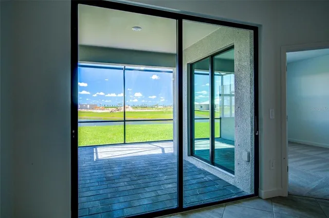 a view of an empty room with wooden floor and a floor to ceiling window