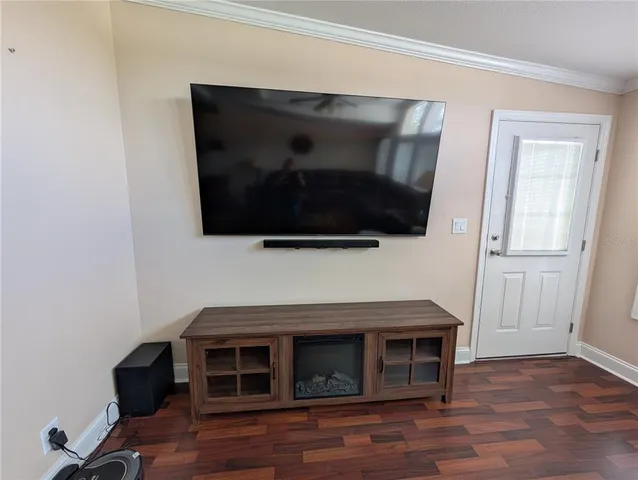 a room with wooden floor and stainless steel appliances