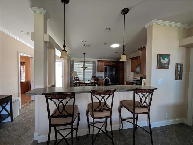 a dining area with a table chairs and a kitchen view