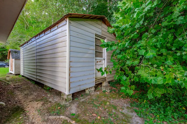 a backyard of a house with a garden and barbeque oven